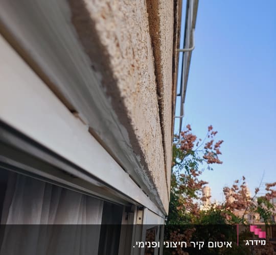 איטום חלון עם חומר איטום על מסגרת מתכת